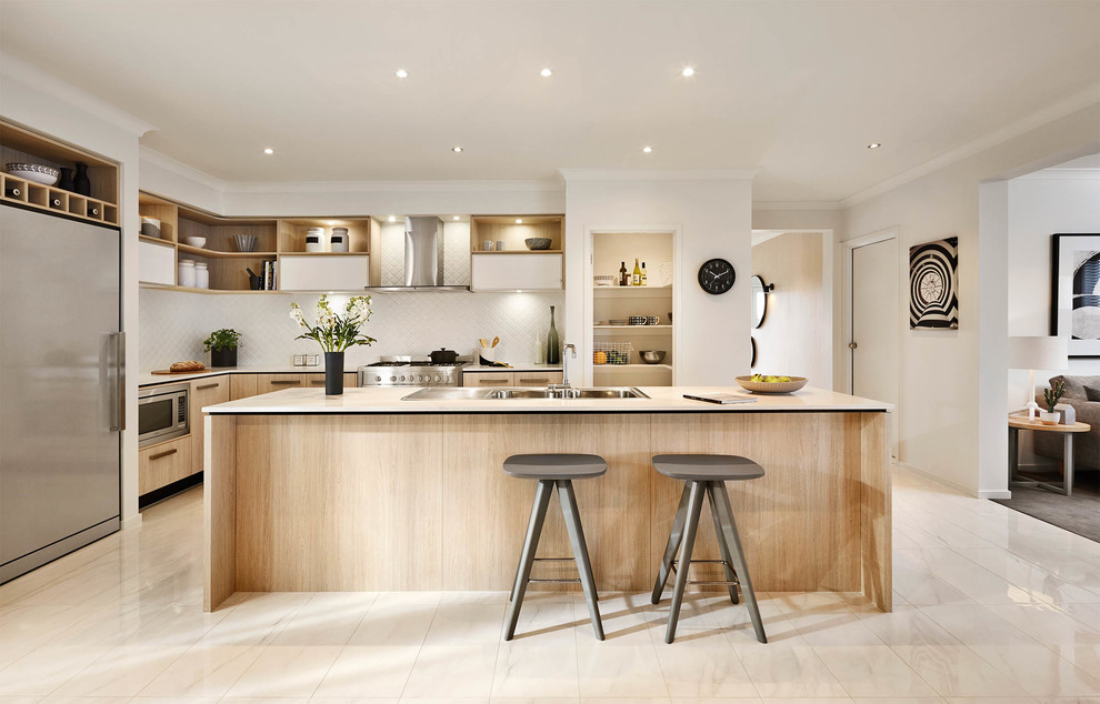 Contemporary l-shaped open plan kitchen in Melbourne with a drop-in sink, flat-panel cabinets, light wood cabinets, white splashback, stainless steel appliances and with island.