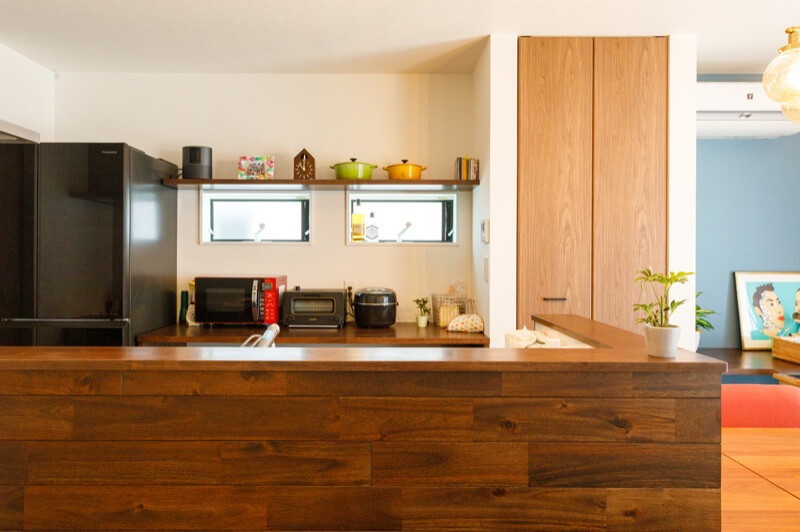 Exempel på ett mellanstort modernt kök, med skåp i ljust trä, svarta vitvaror, mörkt trägolv, en halv köksö och brunt golv