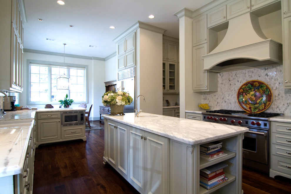 Large traditional u-shaped eat-in kitchen in Houston with a farmhouse sink, raised-panel cabinets, grey cabinets, marble benchtops, grey splashback, mosaic tile splashback, stainless steel appliances, dark hardwood floors and with island.