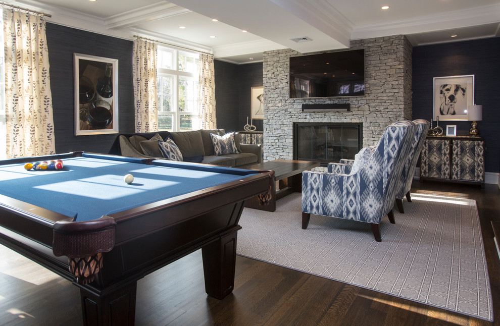 Photo of a large contemporary open concept family room in New York with a game room, blue walls, dark hardwood floors, a standard fireplace, a stone fireplace surround, a wall-mounted tv and brown floor.