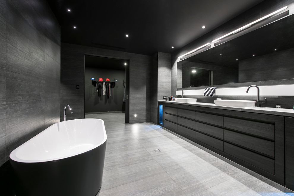 Inspiration for a large contemporary master bathroom in Perth with a vessel sink, flat-panel cabinets, a freestanding tub, black tile, black cabinets and an alcove shower.