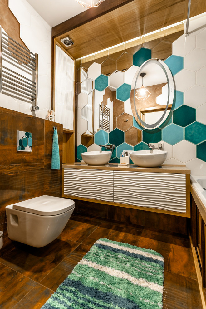 Photo of a small eclectic master bathroom in Yekaterinburg with a wall-mount toilet, white tile, a vessel sink, recessed-panel cabinets, white cabinets, an alcove tub, porcelain tile, brown walls, porcelain floors, solid surface benchtops, brown floor and beige benchtops.