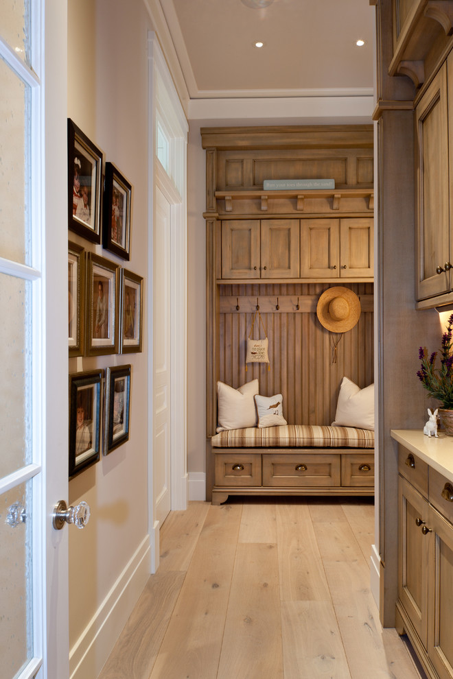 Inspiration for a traditional hallway in Miami with white walls, light hardwood floors and beige floor.
