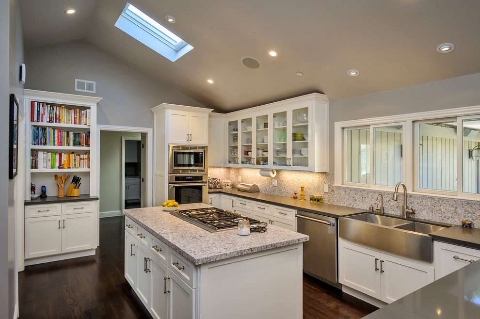 Photo of a traditional u-shaped kitchen in San Francisco with a farmhouse sink, shaker cabinets, white cabinets, beige splashback and stainless steel appliances.