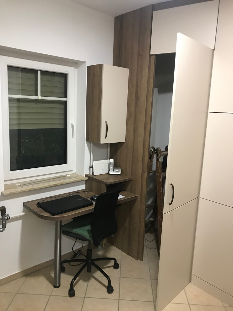 Multifunktionaler, Mittelgroßer Moderner Hauswirtschaftsraum mit Ausgussbecken, flächenbündigen Schrankfronten, beigen Schränken, Laminat-Arbeitsplatte, weißer Wandfarbe, Keramikboden, Waschmaschine und Trockner gestapelt, beigem Boden und brauner Arbeitsplatte in Berlin