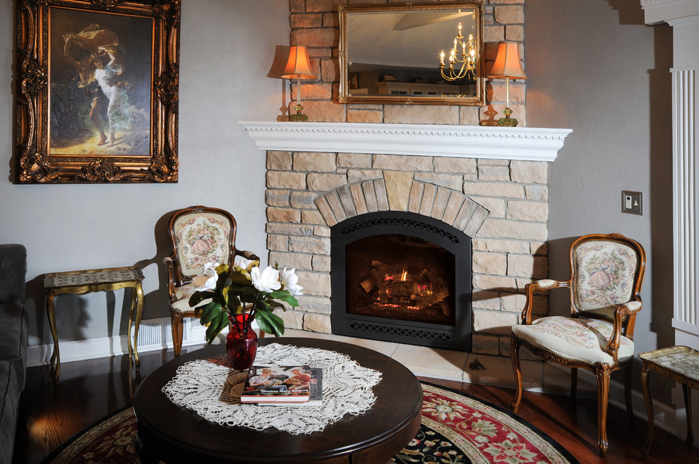 Inspiration for a mid-sized traditional formal enclosed living room in Cleveland with grey walls, dark hardwood floors, a corner fireplace, a stone fireplace surround, no tv and brown floor.