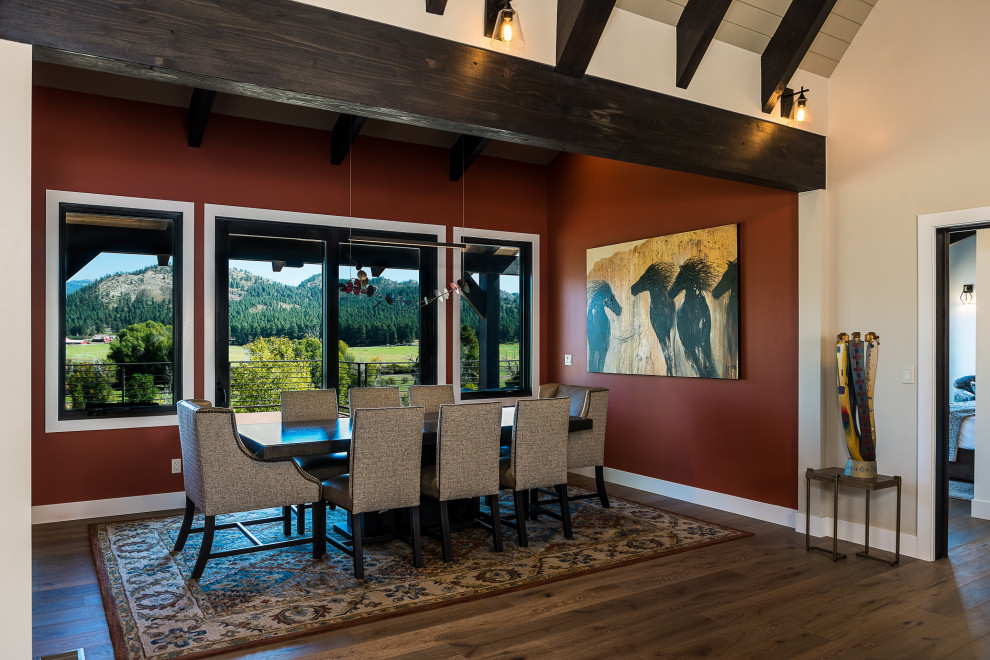 Idée de décoration pour une salle à manger ouverte sur la cuisine chalet de taille moyenne avec un mur rouge, un sol en bois brun, un sol marron et un plafond voûté.