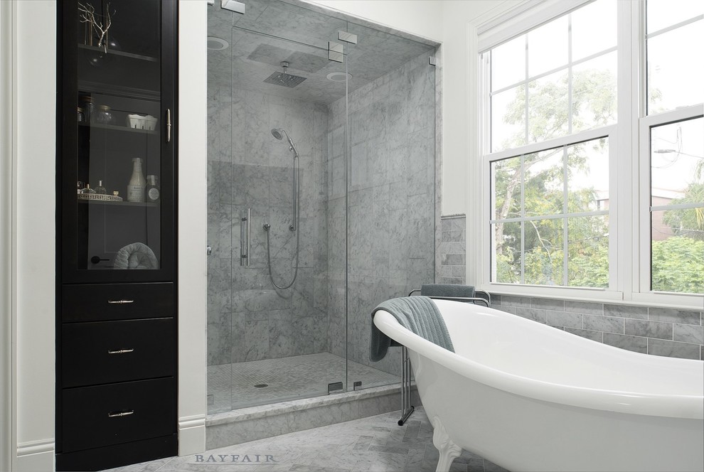 Inspiration for a large transitional master bathroom in Tampa with flat-panel cabinets, dark wood cabinets, a corner shower, gray tile, white walls, a claw-foot tub, stone tile, medium hardwood floors, an undermount sink, marble benchtops, grey floor and a hinged shower door.