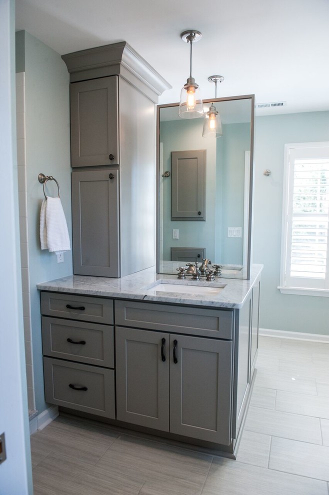 Example of a large transitional master white tile and ceramic tile light wood floor corner shower design in Charlotte with shaker cabinets, beige cabinets, a two-piece toilet, white walls, a drop-in sink and marble countertops