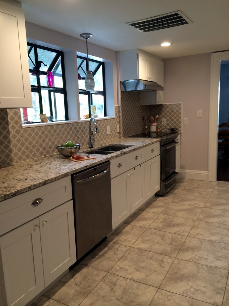 Enclosed kitchen - transitional galley enclosed kitchen idea in Jacksonville with shaker cabinets, white cabinets, gray backsplash and cement tile backsplash