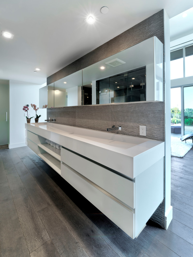 Mid-sized contemporary master bathroom in San Francisco with flat-panel cabinets, white cabinets, a double shower, ceramic tile, grey walls, light hardwood floors, grey floor, a hinged shower door, a trough sink and white benchtops.