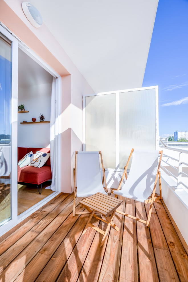 Exemple d'un balcon bord de mer d'appartement avec une extension de toiture et un garde-corps en métal.