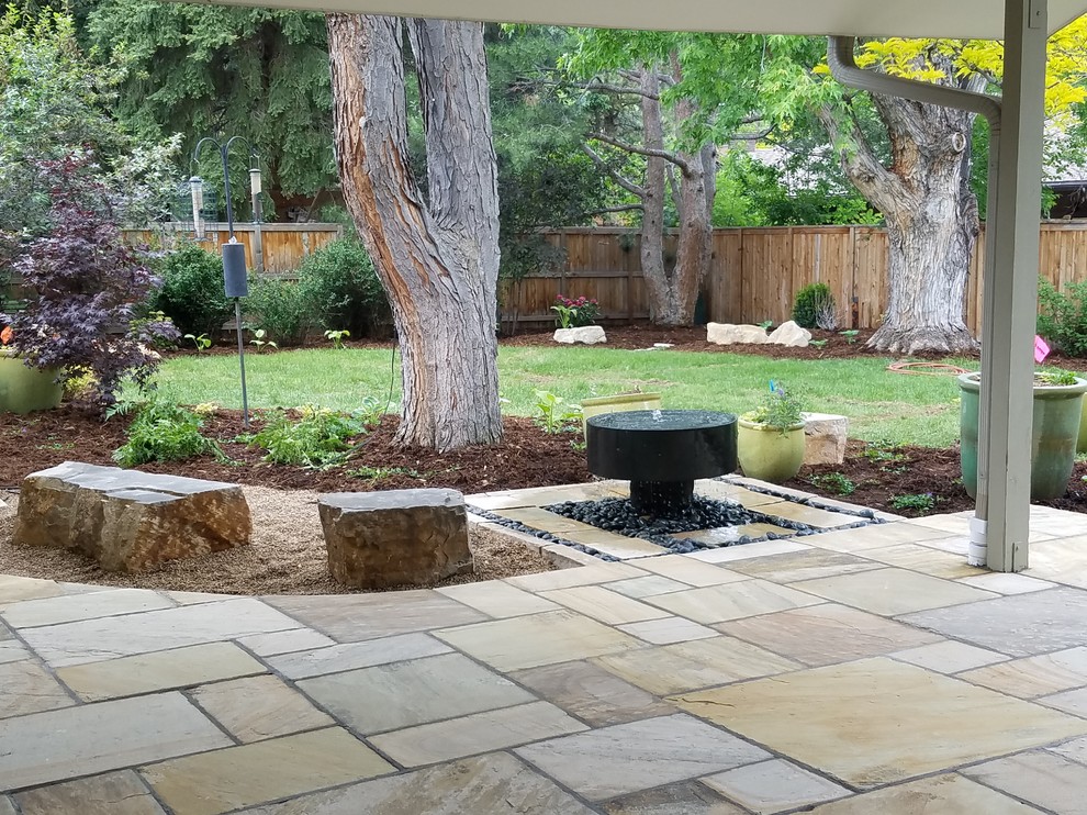 Inspiration for a large backyard partial sun outdoor sport court for summer in Denver with a water feature and natural stone pavers.