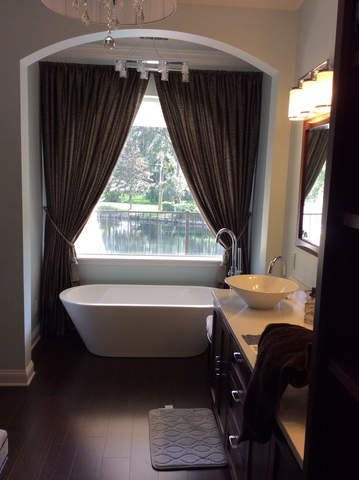 Example of a mid-sized transitional master dark wood floor freestanding bathtub design in Jacksonville with flat-panel cabinets, dark wood cabinets, white walls, a two-piece toilet, a vessel sink and quartz countertops