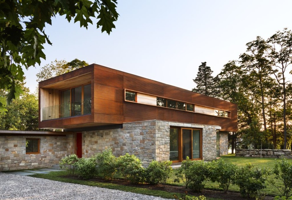 Inspiration for a modern two-storey exterior in New York with mixed siding and a flat roof.