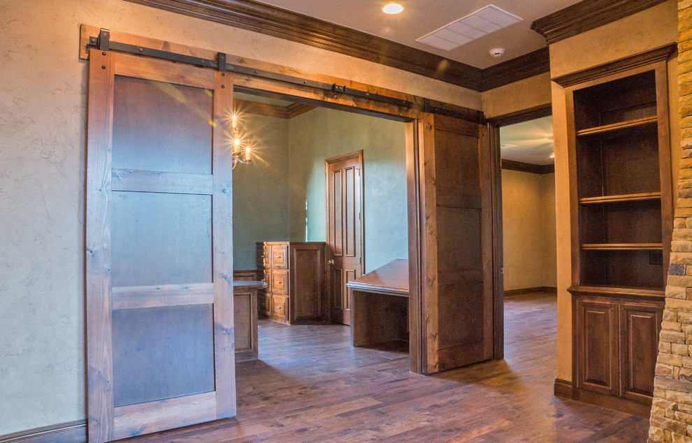 This is an example of a large traditional study room in Oklahoma City with beige walls, dark hardwood floors and a built-in desk.