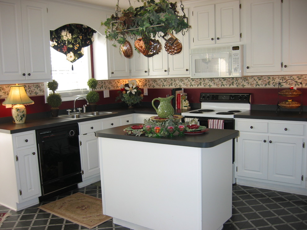 Transitional vinyl floor and black floor kitchen photo with recessed-panel cabinets, white cabinets, laminate countertops, black appliances, an island and black countertops