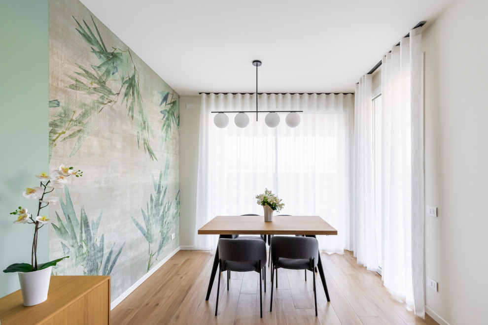 Immagine di un'ampia sala da pranzo aperta verso la cucina contemporanea con pareti verdi, pavimento in gres porcellanato e carta da parati