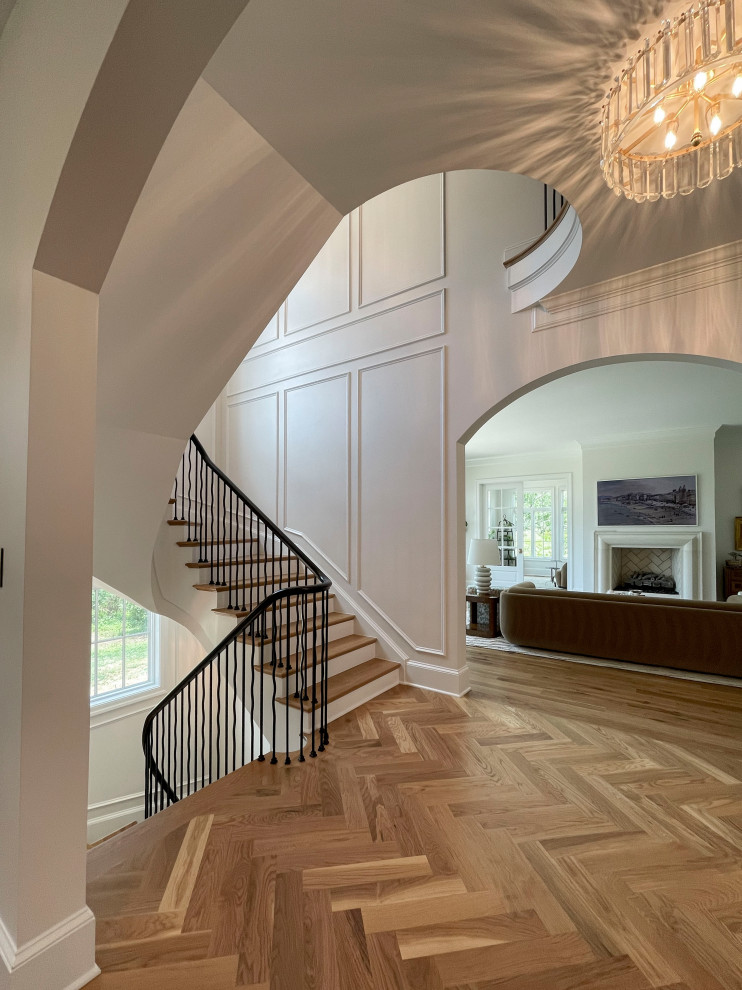 Large transitional wood floating staircase in DC Metro with painted wood risers, mixed railing and decorative wall panelling.