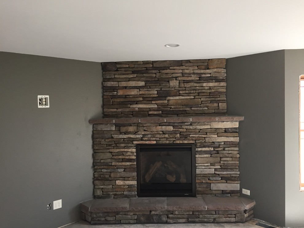 This is an example of a mid-sized arts and crafts formal open concept living room in Minneapolis with grey walls, a corner fireplace, a stone fireplace surround and no tv.