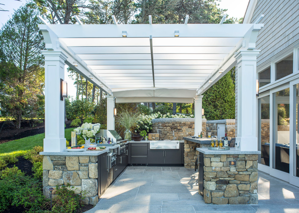Beach style backyard patio photo in Boston with a pergola