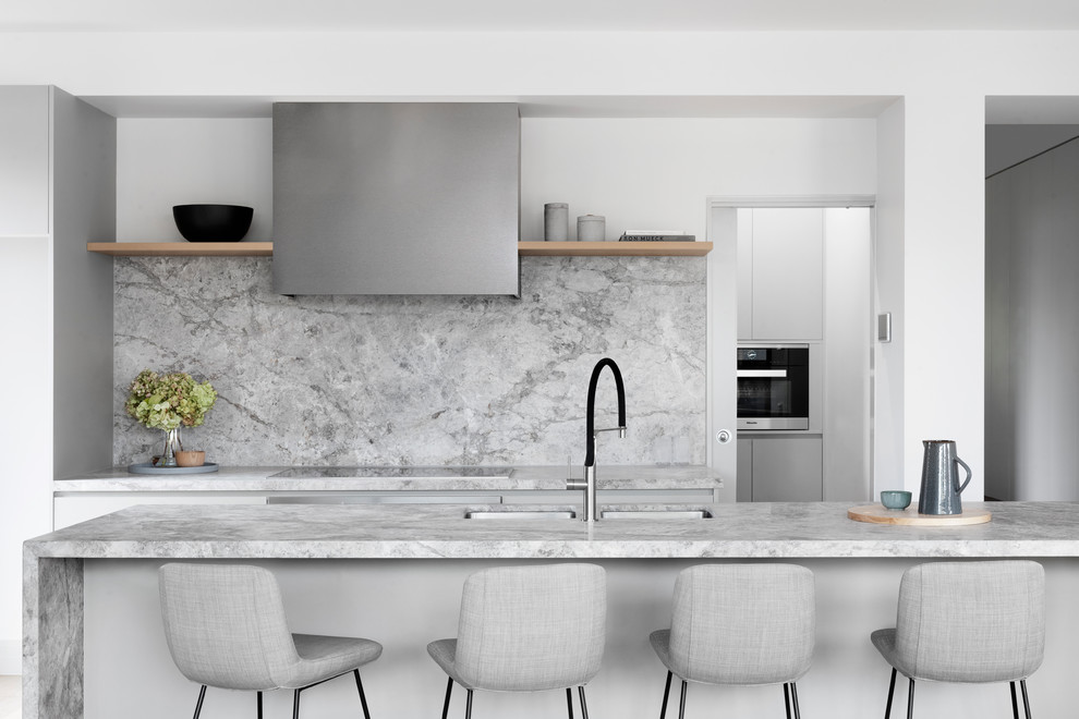 Inspiration for a contemporary galley kitchen in Melbourne with an undermount sink, flat-panel cabinets, grey cabinets, grey splashback, stone slab splashback, with island and grey benchtop.