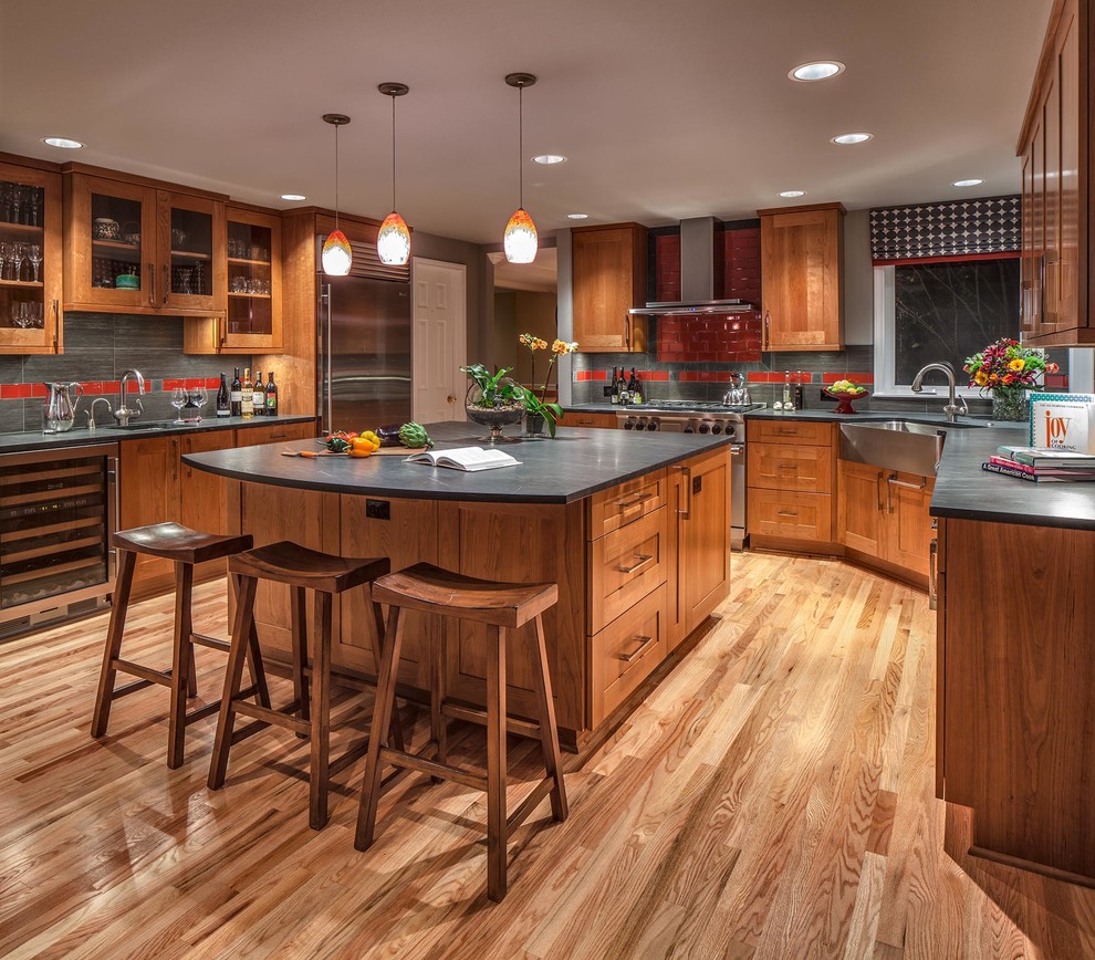 Large traditional u-shaped kitchen in Seattle with a farmhouse sink, soapstone benchtops, shaker cabinets, medium wood cabinets, red splashback, ceramic splashback, stainless steel appliances, with island, medium hardwood floors and brown floor.