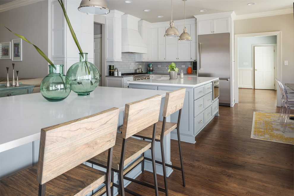 Example of a huge transitional galley medium tone wood floor open concept kitchen design in Raleigh with a farmhouse sink, flat-panel cabinets, white cabinets, quartz countertops, gray backsplash, ceramic backsplash, stainless steel appliances and two islands