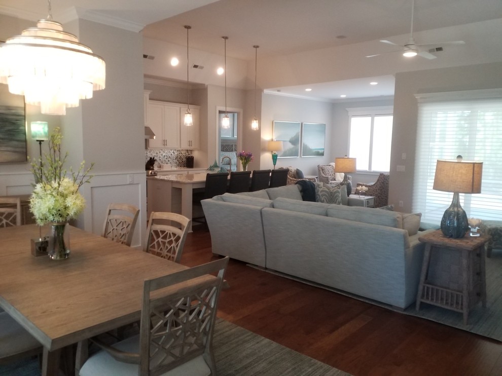 This is an example of a mid-sized beach style open concept family room in Other with grey walls, medium hardwood floors, a standard fireplace, a tile fireplace surround and a wall-mounted tv.