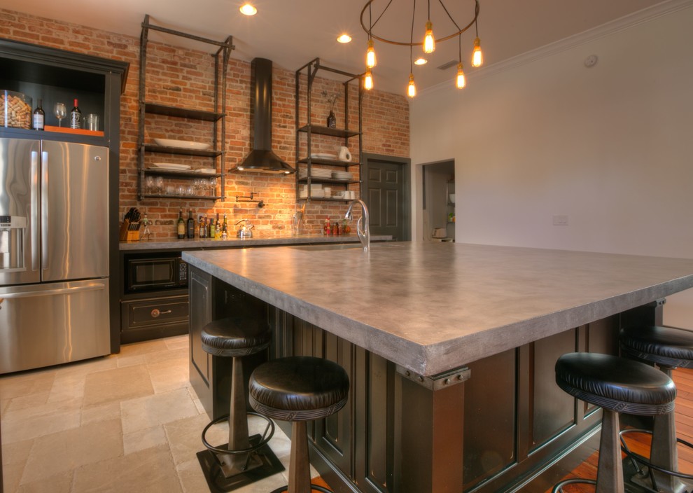 This is an example of a mid-sized industrial l-shaped open plan kitchen in Orlando with an undermount sink, recessed-panel cabinets, brown cabinets, concrete benchtops, red splashback, brick splashback, stainless steel appliances, ceramic floors, with island and beige floor.