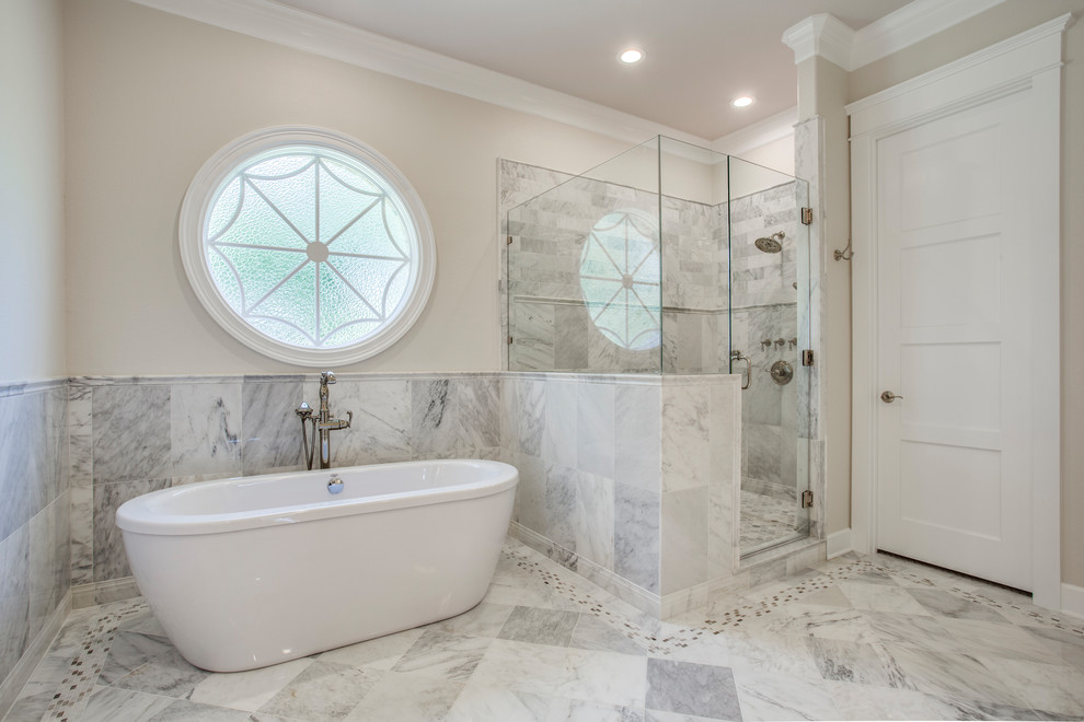 Photo of a mid-sized transitional master bathroom in Dallas with a freestanding tub, a corner shower, gray tile, white tile, marble, beige walls, marble floors, a hinged shower door, recessed-panel cabinets, white cabinets, an undermount sink, granite benchtops, green floor and brown benchtops.