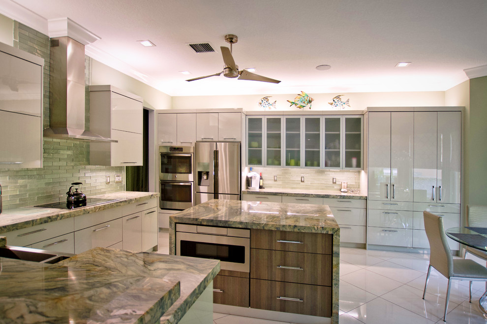 Inspiration for a large contemporary u-shaped open plan kitchen in Miami with a farmhouse sink, flat-panel cabinets, green cabinets, granite benchtops, green splashback, glass tile splashback, stainless steel appliances, marble floors, with island, white floor and green benchtop.