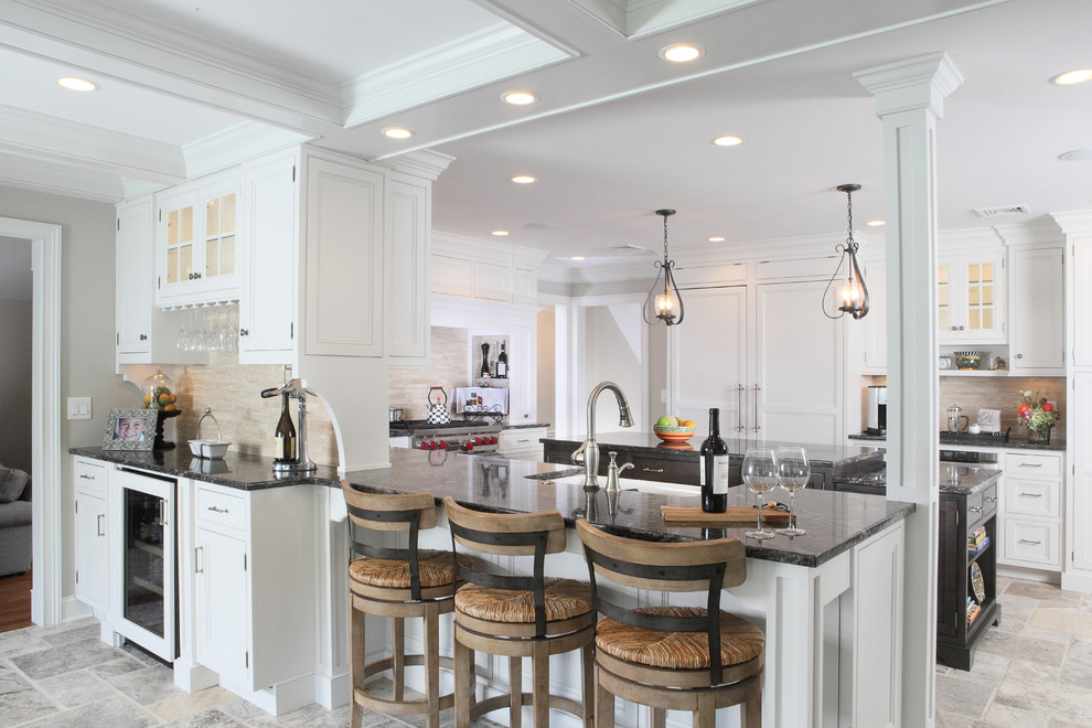 Inspiration for a large transitional u-shaped eat-in kitchen in New York with recessed-panel cabinets, a farmhouse sink, granite benchtops, white cabinets, beige splashback, stone tile splashback, panelled appliances, travertine floors and with island.