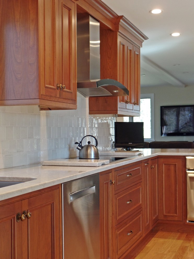 Open concept kitchen - large transitional l-shaped light wood floor open concept kitchen idea with a single-bowl sink, beaded inset cabinets, medium tone wood cabinets, quartzite countertops, white backsplash, ceramic backsplash, stainless steel appliances and no island