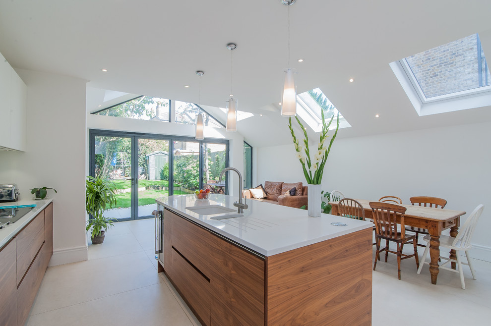 Mid-sized contemporary eat-in kitchen in Surrey with an integrated sink, flat-panel cabinets, medium wood cabinets, quartzite benchtops, white splashback, stainless steel appliances, ceramic floors and with island.