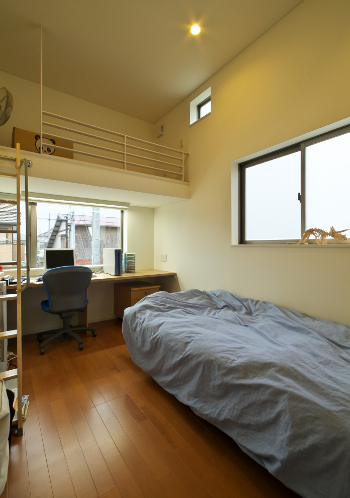 Bild på ett mellanstort funkis könsneutralt tonårsrum kombinerat med skrivbord, med vita väggar och plywoodgolv