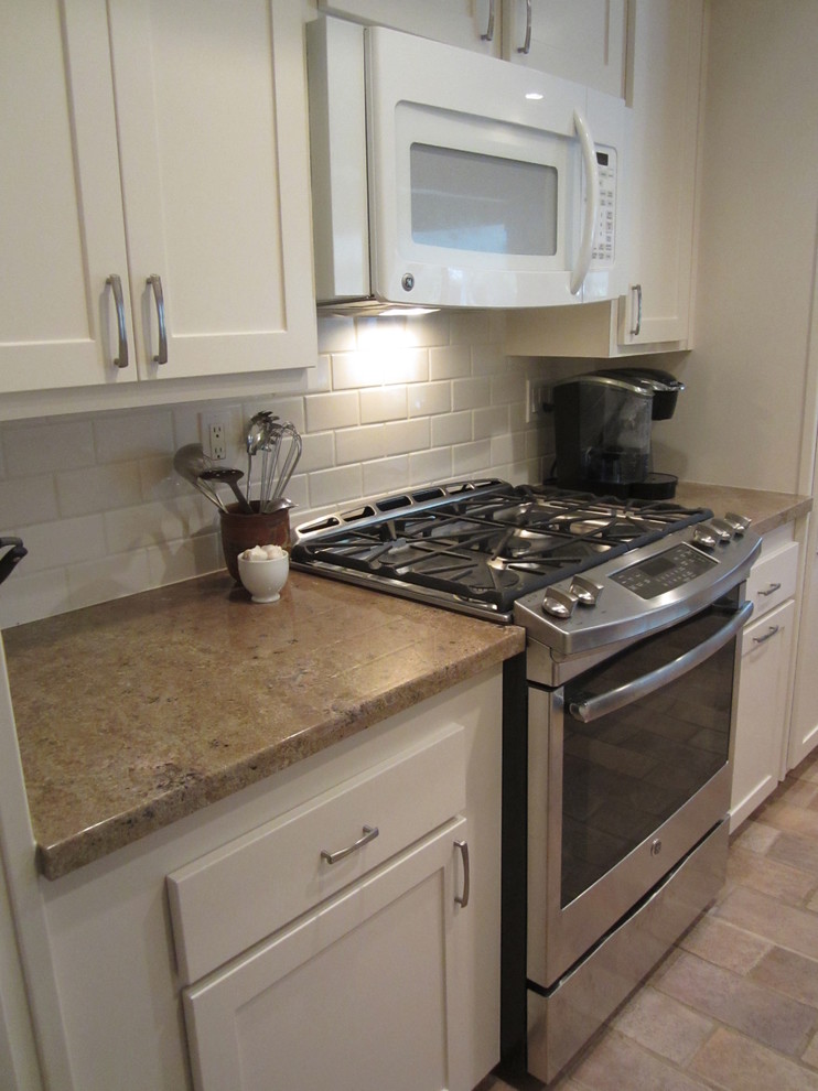 Small transitional galley ceramic tile eat-in kitchen photo in Orange County with a double-bowl sink, shaker cabinets, white cabinets, granite countertops, white backsplash, ceramic backsplash, stainless steel appliances and no island
