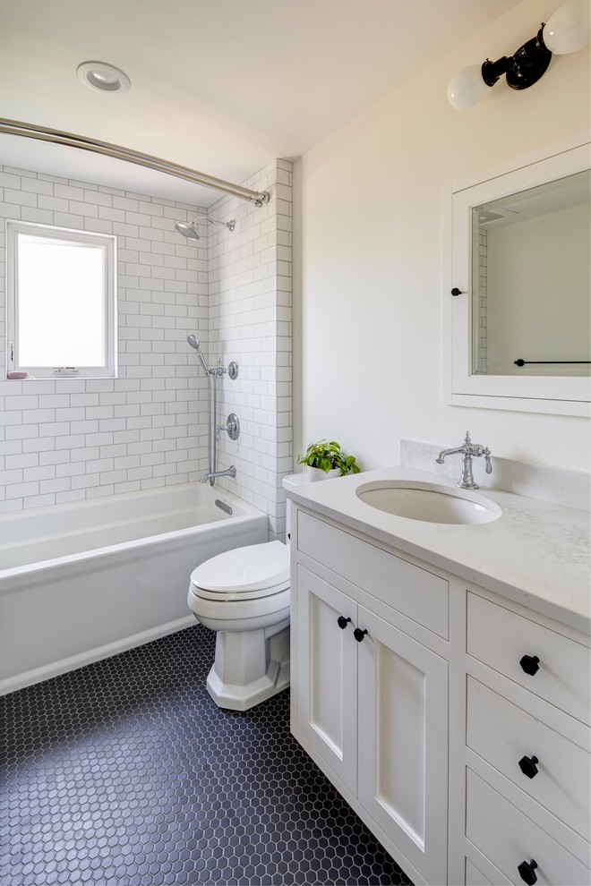 Inspiration for a mid-sized traditional 3/4 bathroom in Portland with recessed-panel cabinets, white cabinets, an alcove tub, a shower/bathtub combo, a two-piece toilet, subway tile, beige walls, porcelain floors, an undermount sink, quartzite benchtops, black floor and white benchtops.