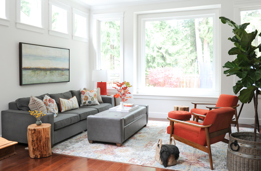 Photo of a mid-sized transitional open concept living room in Vancouver with white walls, dark hardwood floors, no tv, a standard fireplace and a wood fireplace surround.