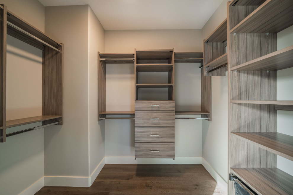 Photo of a large contemporary gender-neutral walk-in wardrobe in Vancouver with flat-panel cabinets, medium wood cabinets, medium hardwood floors and brown floor.