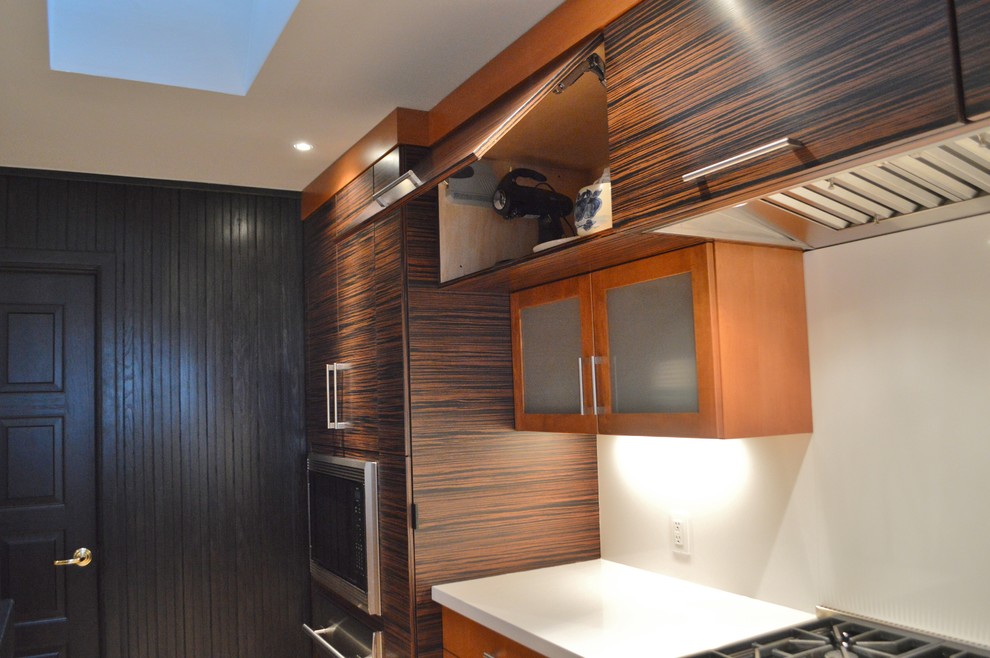Example of a large light wood floor kitchen design with flat-panel cabinets, dark wood cabinets, quartzite countertops, white backsplash, stone slab backsplash, stainless steel appliances and an island
