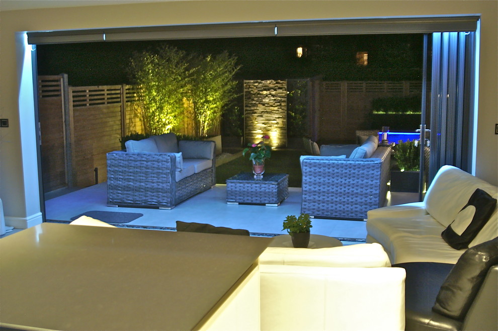 Mid-sized contemporary backyard full sun formal garden in London with a water feature and concrete pavers for summer.