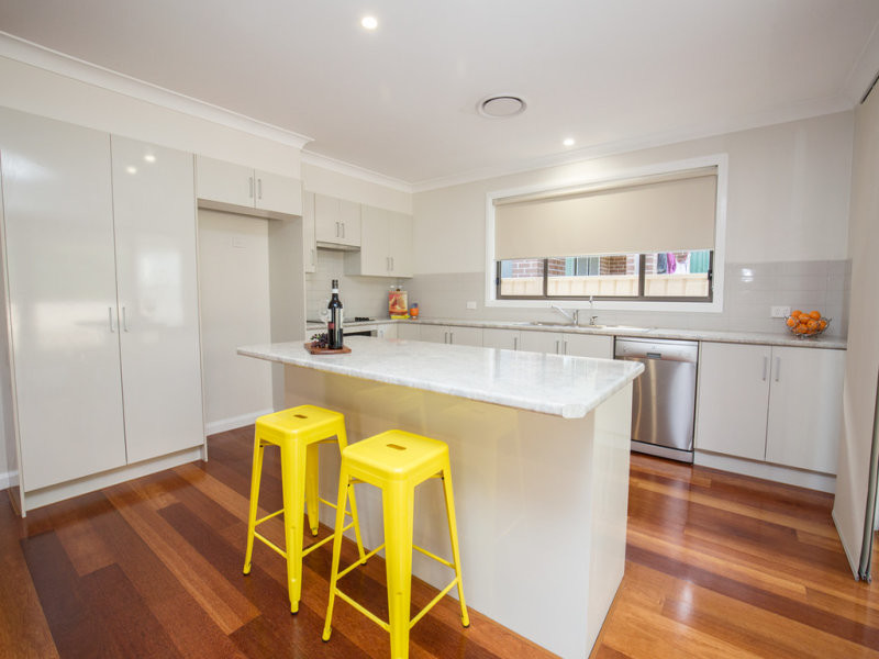 Mid-sized transitional u-shaped kitchen in Newcastle - Maitland with a double-bowl sink, granite benchtops, grey splashback, ceramic splashback, stainless steel appliances, light hardwood floors and with island.
