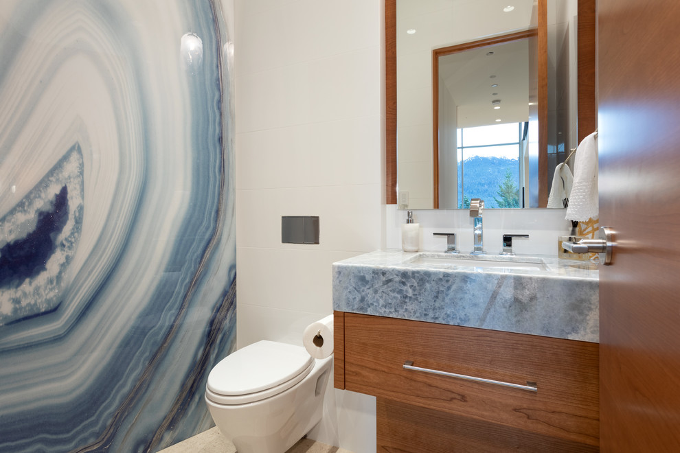 Photo of an expansive contemporary bathroom in Vancouver with flat-panel cabinets, white tile, ceramic tile, ceramic floors, engineered quartz benchtops, beige floor, medium wood cabinets, a wall-mount toilet, blue walls, an undermount sink and grey benchtops.