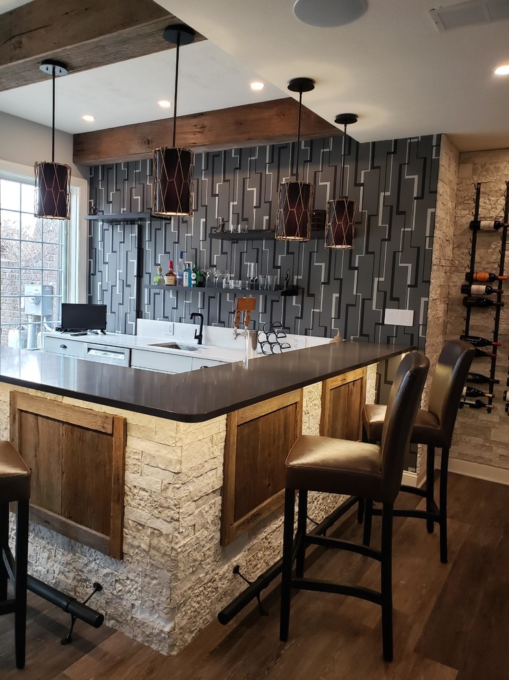 Photo of a large eclectic u-shaped seated home bar in Other with an undermount sink, shaker cabinets, white cabinets, quartz benchtops, multi-coloured splashback, light hardwood floors, grey floor and grey benchtop.