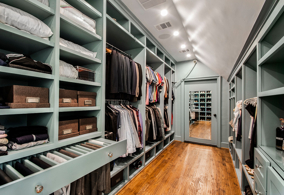 Photo of an expansive traditional gender-neutral walk-in wardrobe in Dallas with medium hardwood floors, open cabinets and green cabinets.