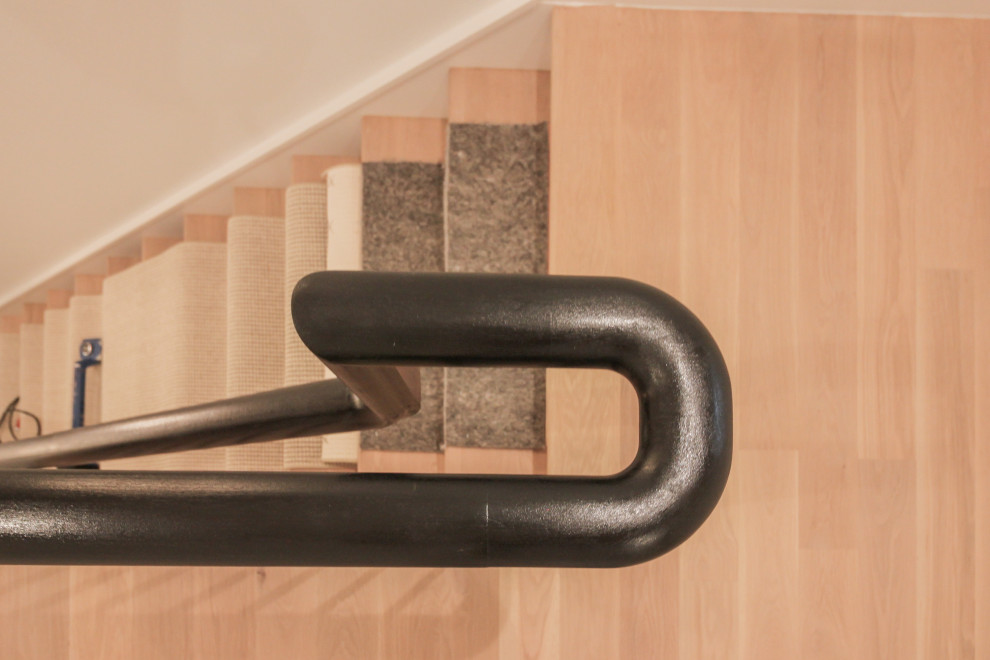 Réalisation d'un grand escalier peint minimaliste en U avec des marches en bois, un garde-corps en matériaux mixtes, boiseries et palier.