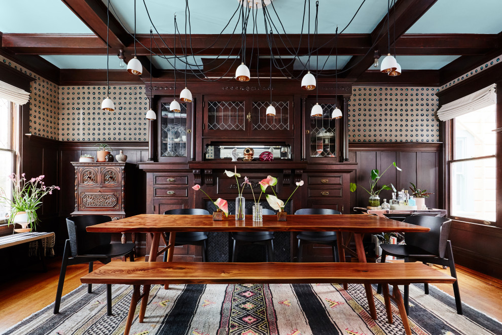 Exemple d'une salle à manger éclectique fermée et de taille moyenne avec un mur marron, une cheminée standard, un manteau de cheminée en carrelage, un plafond à caissons et du papier peint.