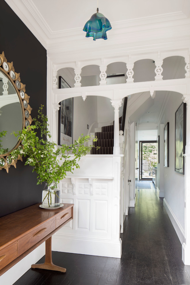 Inspiration for a small traditional entry hall in Hamburg with dark hardwood floors, brown floor and black walls.
