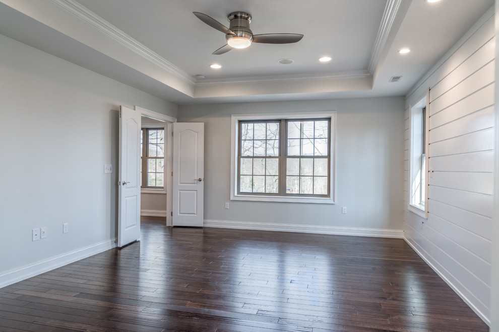 Large transitional master dark wood floor and brown floor home design photo with gray walls